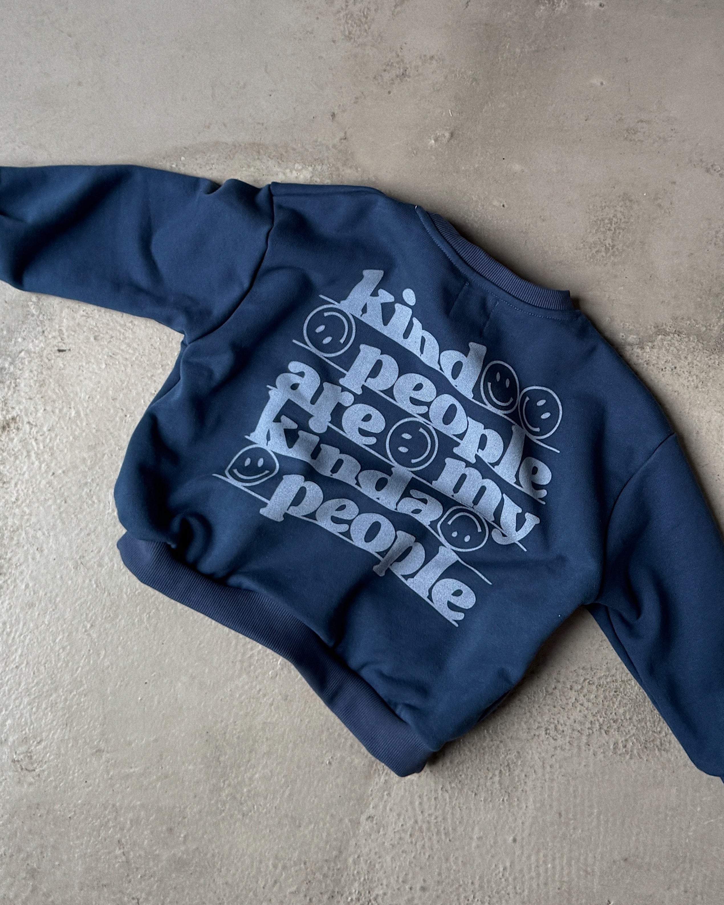 Blue hoodie with white text on a concrete surface